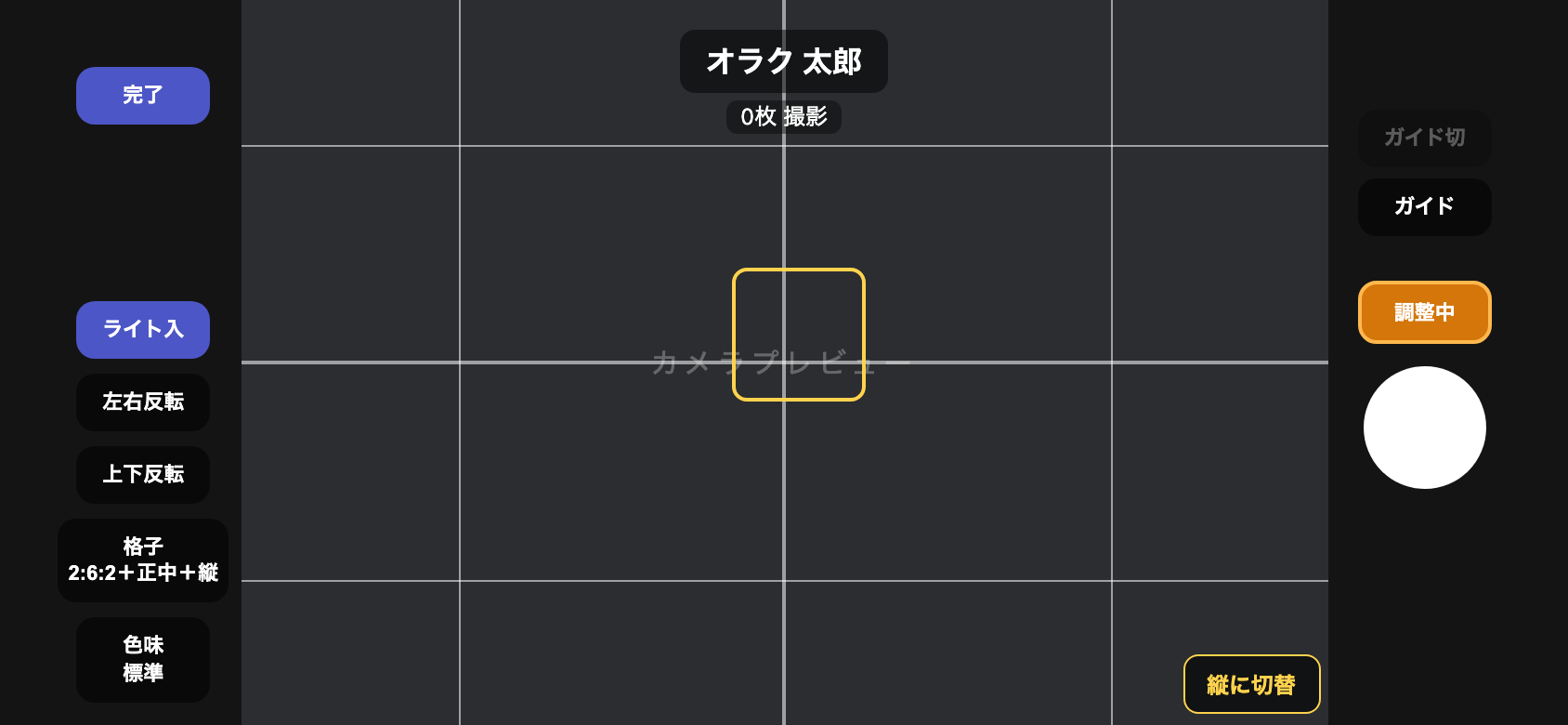 撮影画面。タップした位置に黄色いフォーカス枠が表示され、右側のオレンジの半押しボタンが「調整中」表示になっている
